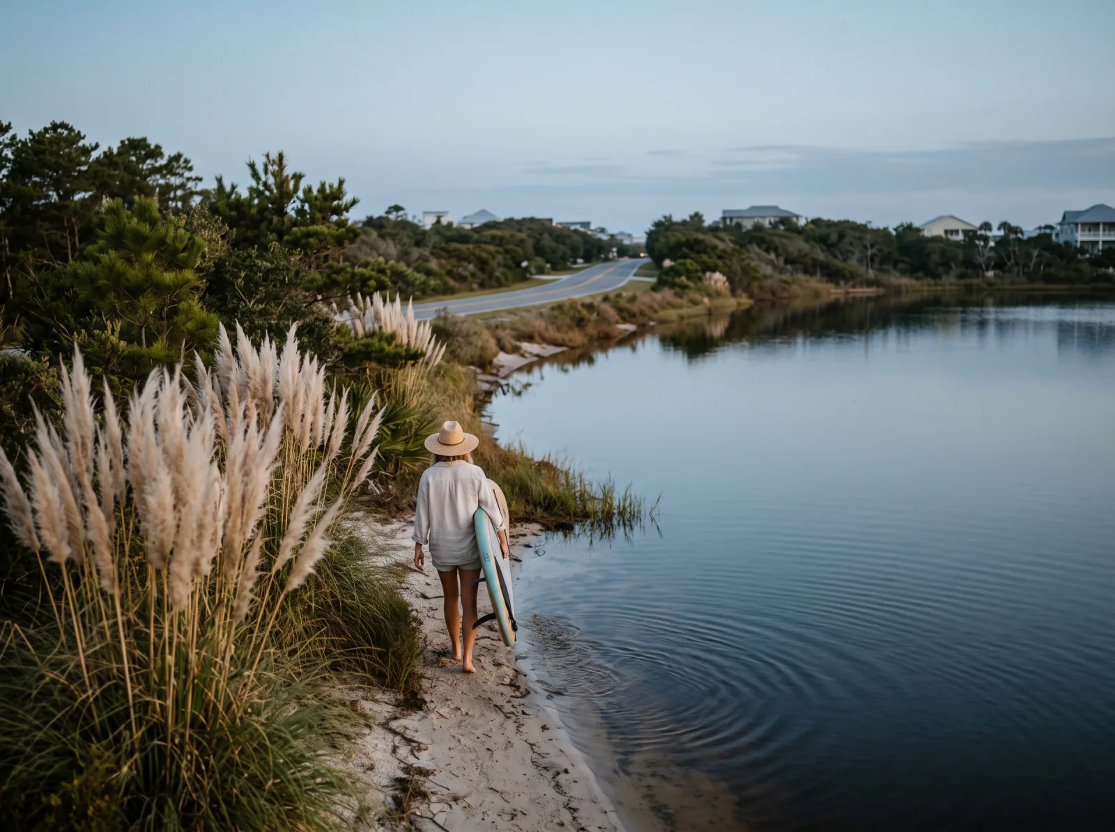 Paddler moving across calm Oyster Lake water near the Dune Allen shore at morning